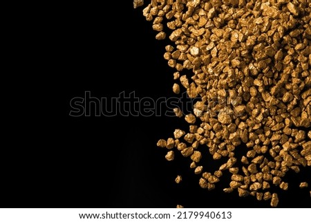 Pile of gold nuggets on black background, flat lay. Space for text