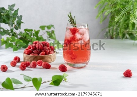 Summer refreshing non-alcoholic cocktails. Raspberry lemonade garnished with fresh rosemary. Summer raspberry beverage with sparkling water. Copy space. Royalty-Free Stock Photo #2179945671