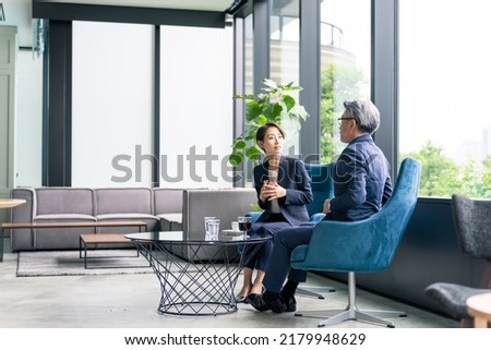 Couple of Asian businessperson meeting in lounge. Royalty-Free Stock Photo #2179948629