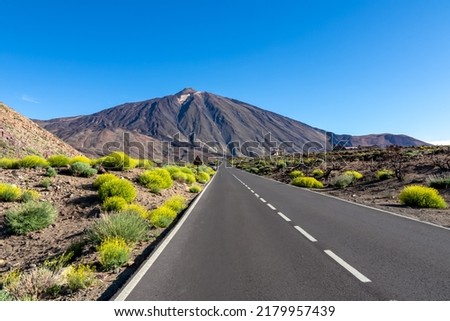 Scenic mountain road leading to volcano Pico del Teide, Mount El Teide National Park, Tenerife, Canary Islands, Spain, Europe. Volcanic dry landscape. Road trip on a sunny summer day. Freedom vibes Royalty-Free Stock Photo #2179957439