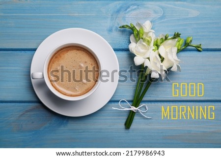 Good Morning! Aromatic coffee and flowers on light blue wooden table, flat lay