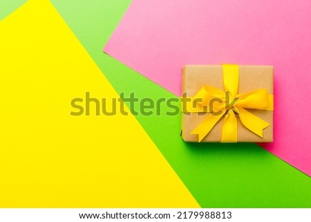 holiday paper present tied yellow ribbon bow top view with copy space. Flat lay holiday background. Birthday or christmas present. Christmas gift box concept with copy space.