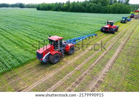 Tractors with plow on soil cultivating. tractor bowling field, drone view. Cultivated plant and soil tillage. Agricultural tractors on field cultivation. Tractor disk harrow on plowing farm field.