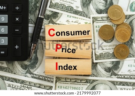 CPI, consumer price index symbol. Wooden blocks with words CPI, consumer price index on dollar bills with a calculator, coins.  Business and CPI, Business and consumer price index concept. Royalty-Free Stock Photo #2179992077