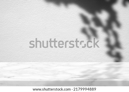 White Marble Table with Hanging Leaves Shadow on Concrete Wall Texture Background, Suitable for Product Presentation Backdrop, Display, and Mock up.