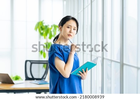 Asian woman in modern office. Business casual. Royalty-Free Stock Photo #2180008939