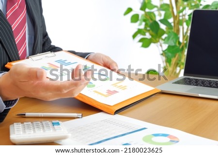 A businessman man explaining using graph materials Royalty-Free Stock Photo #2180023625