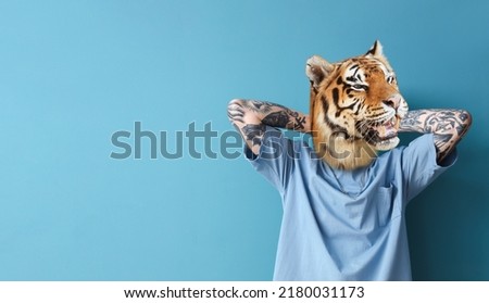 Tattooed man with head of tiger on blue background