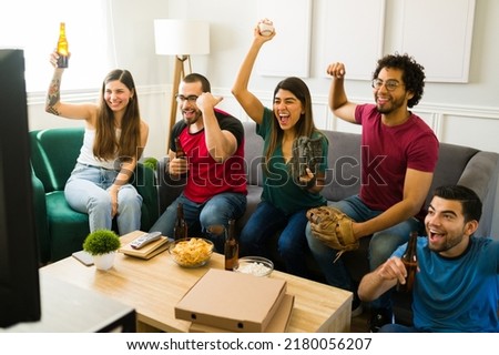 Happy sports fans cheering the baseball championship while watching the game on tv