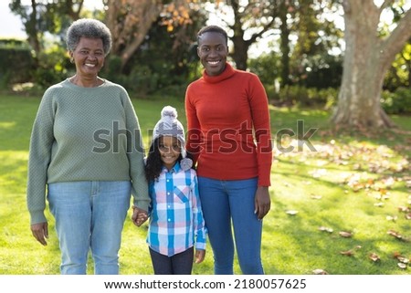 Image of happy african american grandmother, mother and daughter in garden. Family and spending quality time together concept.