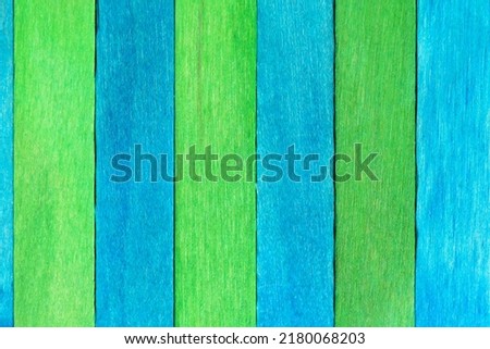 Two-tones wooden textured background in blue and green colors. Alternating wooden painted boards arranged vertically on a row. Green and blue wooden background with natural structure.