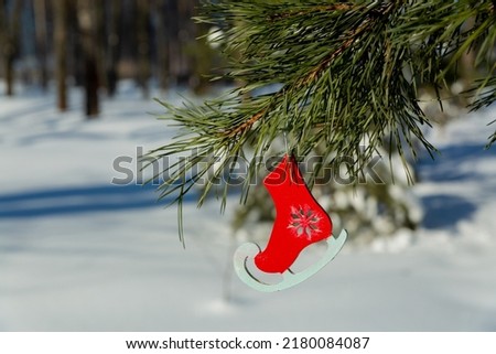 Christmas pendant toy figure skates hanging on a Christmas tree branch.