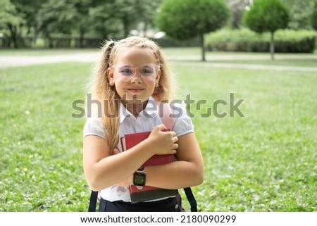 close up portrait of blonde schoolgirl in glasses white shirt with pink backpack back to school