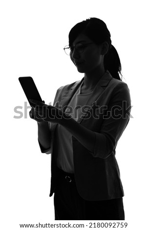 Silhouette of young asian woman using a smart phone. Royalty-Free Stock Photo #2180092759