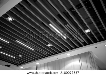 Ventilation and air conditioning system in industrial, exhibition hall or commercial premises with lighting, under the ceiling. Ventilation pipes and hoods. Royalty-Free Stock Photo #2180097887