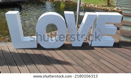 Wedding ceremony decorations, flowers. Large decorative letters are composed in the word "LOVE".