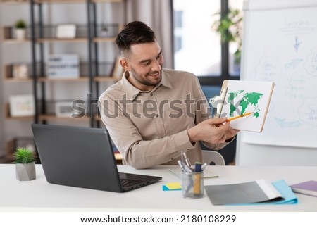 distance education, school and remote job concept - happy smiling male geography teacher with world map and laptop computer having online geography class at home office Royalty-Free Stock Photo #2180108229