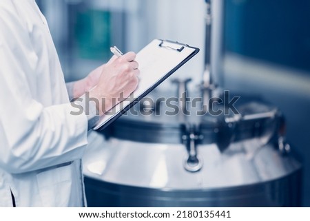 medicine science factory staff worker check quality products sterilize in autoclave tank in check list. Royalty-Free Stock Photo #2180135441