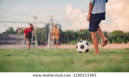 Action sport outdoors of kids having fun playing soccer football for exercise in community rural area. Picture with copy space.