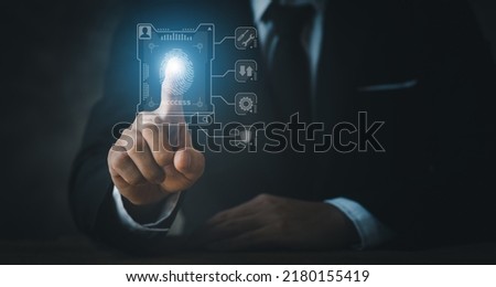 Businessman wearing a suit pointing to a hologram, hologram icon fingerprint encryption, protecting access to confidential information by using fingerprint technology. Fingerprint encryption concept.