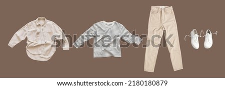 Flying cotton longsleeve, beige jeans, denim shirt, white leather sneakers isolated on brown background. Clean white Unisex T-shirt. Branding clothes. Mock up for your design. Autumn Women's Clothing Royalty-Free Stock Photo #2180180879