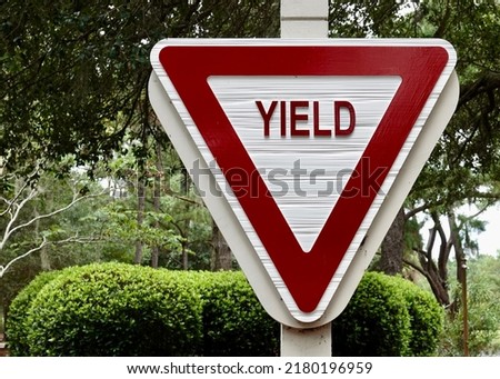 Red Wooden Yield Sign in Park            