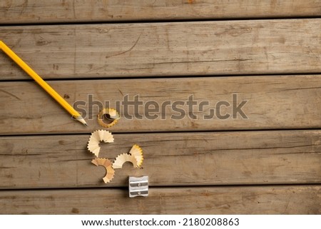 Image of pencil, sharpener and peelings on wooden background. School equipment, tools, learning and education concept.