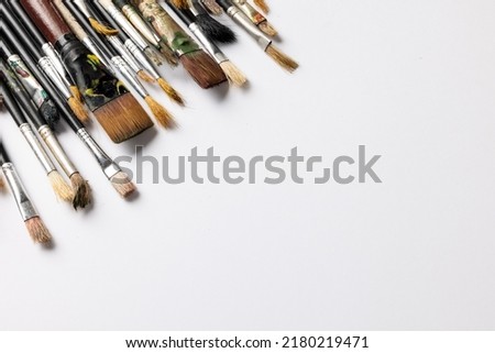 Image of composition of diverse brushes on white surface with copy space. School equipment, tools, learning and creativity concept.