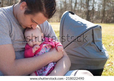 Young father is having some nice time with his baby on a sunny day