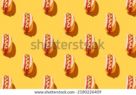Pattern of fresh made hot dogs on yellow pastel background Royalty-Free Stock Photo #2180226409