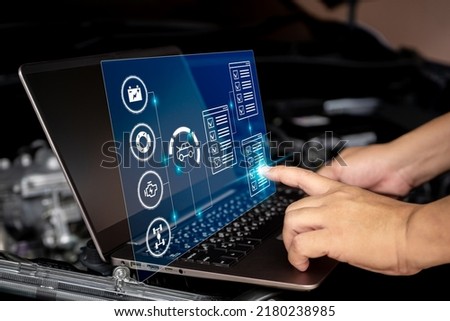 Car business and service concept, Technician use laptop to check car service in the digital list battery brake engine suspension on virtual screen,Technology of car maintenance in car service center Royalty-Free Stock Photo #2180238985