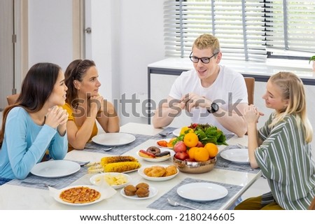 Group of caucasian friends and neighbor joining the lunch together at home talking and catching up on each other while having good food