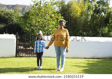 Image of happy african american grandmother and granddaughter in garden. Family and spending quality time together concept.