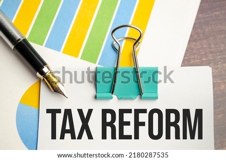 White notepad text TAX REFORM with diagram and pen