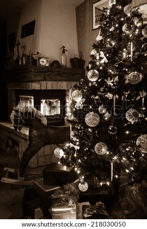 Old fashioned christmas tree with rocking horse, gift packages, and fireplace in background ( focus point on the xmas tree)