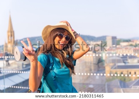 Portrait of traveler girl with travel backpack smiling and making victory sign