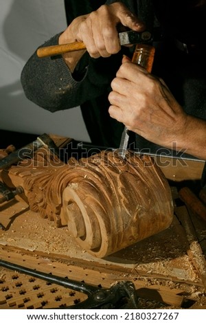 Craftsman's hands working on wood carving, with gouge and chisel Cabinetmaker, traditional carpentry Royalty-Free Stock Photo #2180327267