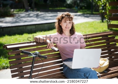  remote workers. middle aged woman using a laptop connecting to the Internet outdoor. Working from Anywhere.
