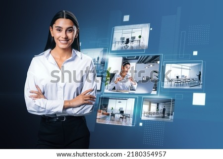 Happy young european businesswoman with folded arms and creative digital picture gallery on blue background. Photo album and media technology concept
