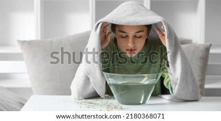 Young woman doing steam inhalation at home to soothe and open nasal passages Royalty-Free Stock Photo #2180368071