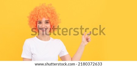 happy freaky woman in curly clown wig pointing finger, gesture and emotions. Woman isolated face portrait, banner with copy space.