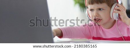 Little child not satisfied with something, point with finger on laptop screen