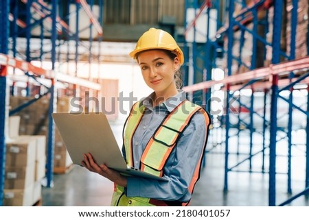 Portrait of female worker using laptop working in warehouse, Industrial and industrial workers concept. Royalty-Free Stock Photo #2180401057
