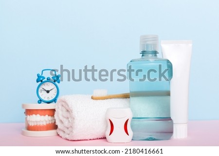 Mouthwash and other oral hygiene products on colored table top view with copy space. Flat lay. Dental hygiene. Oral care kit. Dentist concept. Royalty-Free Stock Photo #2180416661