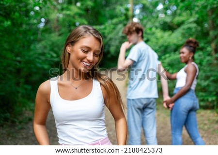 Distracted guy turning around and looking to another woman while walking with his girlfriend Royalty-Free Stock Photo #2180425373