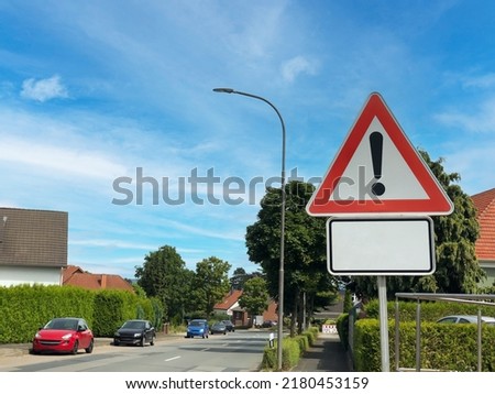Road sign with red exclamation mark warning for dangerous situation in street on city. Blank white frame with copy space.