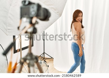 Beautiful model posing front professional camera at studio.