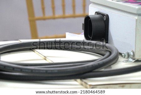 EV charger or electric vehicle charger cord along with its connector board in the background with selective focus