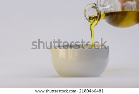 Olive oil. Spain olive oil in glass transparent bowl with tomato. Close-up, Isolated on white background.