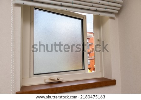 Frosted glass window in a slightly opened state Royalty-Free Stock Photo #2180475163